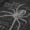 Dibujo de araña con letras en inglés parte trasera de la sudadera.
